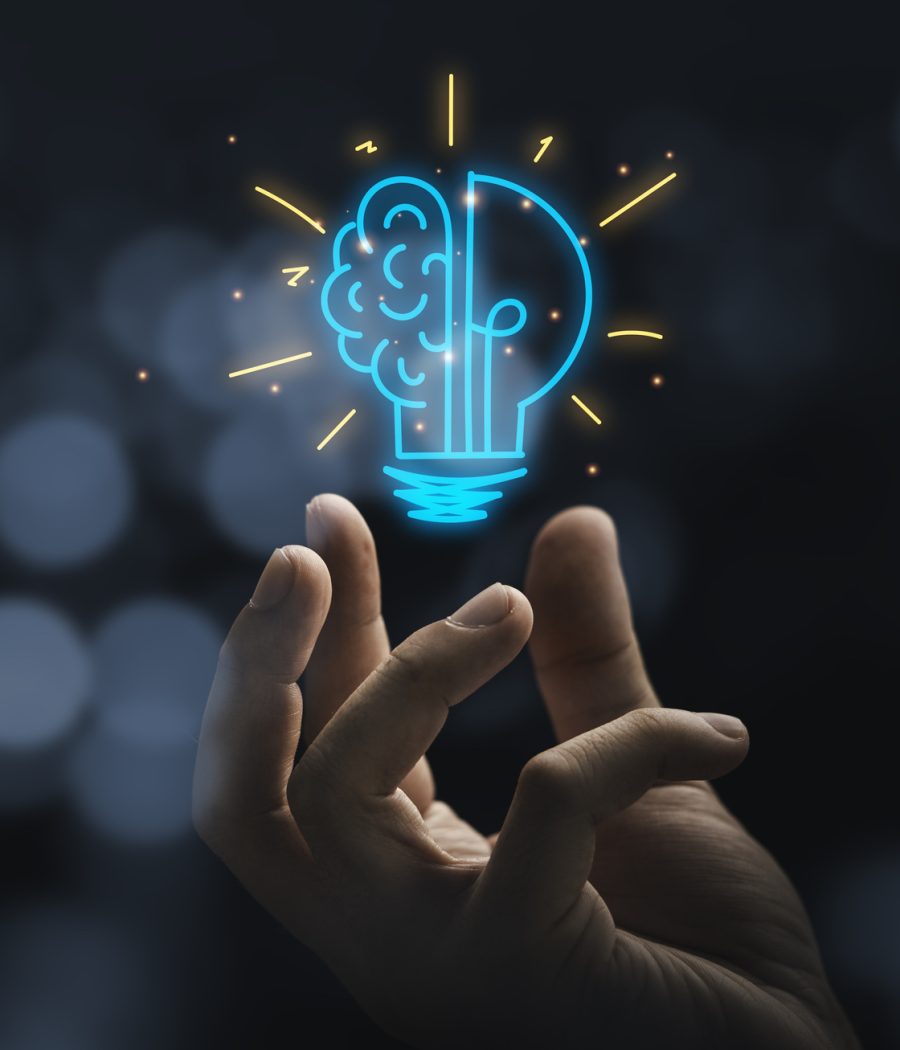 Hand holding drawing virtual lightbulb with brain on bokeh background for creative and smart thinking idea concep